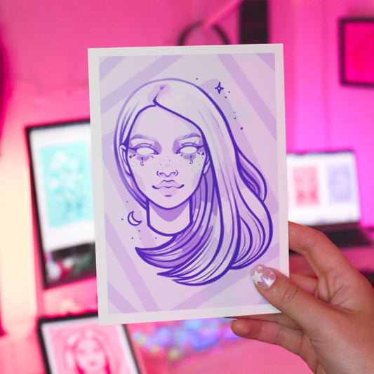 Hand holding a purple art print drawing of a ghost woman's face.